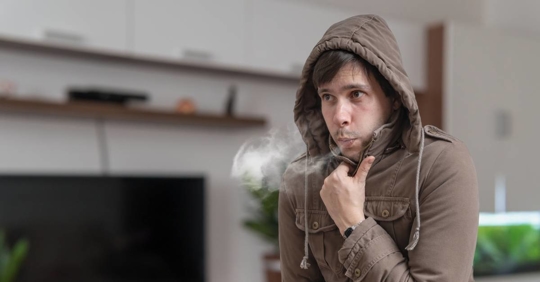 Young man feels cold at home.