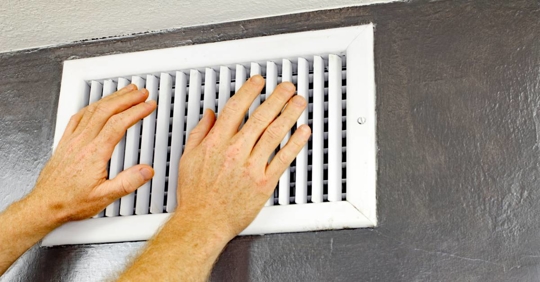 Two Hands in Front of an Air Vent